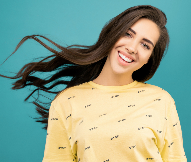 Zahnarztpraxis Dr. Gernot Wagner - Endodontie - Frau mit perfekten Zähnen lächelt vor türkisem Hintergrund